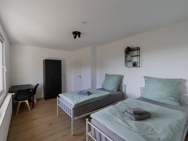 Einzelzimmer mit Bett und Schreibplatz