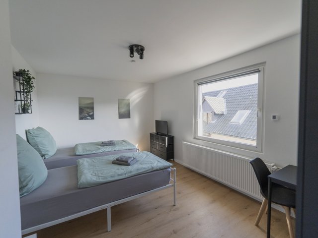 Zimmer der Wohnung mit Betten und Schreibtisch
